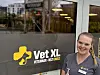 Dyrepleier foran inngangen til Vet XL Ålesund med klinikkens logo på glassdøren.