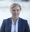 Portrett av ei kvinne i blå blazer mot lys bakgrunn.