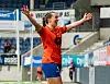 Fotballspiller i oransje drakt jubler med armene hevet på en stadion.
