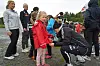 Barn står samlet på en fotballbane mens en person bøyer seg ned for å skrive autografer.