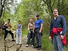Fem personer står på en skogssti omgitt av trær og røtter.