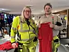 To personer står inne i en sportsbutikk og holder opp røde fotballplagg.