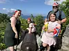 Fire personer står rundt en gammel kanon ved et utsiktspunkt med fjell og trær.