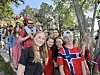En stor gruppe mennesker står tett sammen i en park med trær og grønt bak.