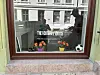 Butikkvindu med teksten The Football Dots, to potter med blomster og en fotball dekorert i vinduet.