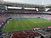 Stor fotballstadion med grønn bane og tettpakket publikum på tribuner rundt hele arenaen.