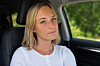 Kvinne med blondt hår sitter i passasjersetet i en bil.