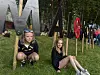 To unge personer sitter på gresset foran store bokstaver i en park.