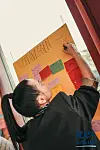 En person skriver på en stor plakattavle med post-it-lapper i et møte rom.