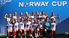 En gruppe unge spillere poserer foran en blå vegg med teksten Norway Cup.