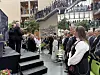 Et stort innendørs atrium med mange mennesker, trapper og publikum langs rekkverk på flere etasjer.