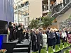 Et orkester opptrer på en scene i et stort atrium med publikum, trapp og balkonger.