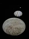 To planetmodeller henger mot en svart bakgrunn, med en mindre kule over en større, gråaktig overflate.