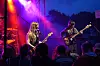 Band spiller på en opplyst scene foran et publikum i mørke silhuetter.
