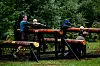Tre personer på en trehinderbane med stokker og støttebjelker i en park.