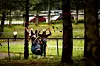 Et barn sitter i en taubane festet mellom to trær i en park.