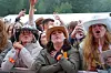 Engasjert konsertpublikum med hender i været foran en scene.