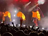 Konsert med artister, store flammer og et publikum med hendene i været.