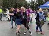 En gruppe personer smiler og poserer sammen på en utendørs samling.