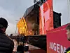 Publikum står foran en stor utendørsscene med røde skjermer og scenelys.