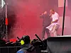 To artister opptrer på en scene med rødt lys og røyk.