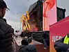 Publikum ser et sceneshow med flammer foran en utendørsscene.