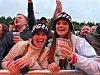 En gruppe glade festivalgjengere jubler bak et sperregjerde.
