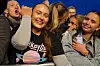 Unge publikummere smiler og vinker ved en scenekant.