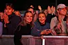 En gruppe konsertgjengere jubler og filmer bak et metallgjerde.