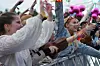 Festivalgjengere jubler og rekker hendene i været bak en sikkerhetsbarriere.