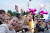 Unge festivalgjengere jubler og synger i en folkemengde foran et opplyst pariserhjul.