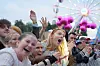 Unge festivalgjengere jubler og synger i en folkemengde foran et opplyst pariserhjul.