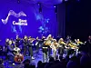 Orkester med strykere opptrer på en scene med Fjord Cadenza-logo i bakgrunnen.