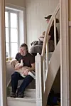 To voksne sitter i en trapp og holder hver sin baby.