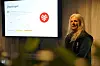 Kvinne står ved en opplyst skjerm med teksten «Oppdraget» i et mørkt lokale.