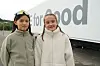 To barn står utendørs foran en stor lastebil med teksten «for good».