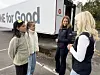 Tre kvinner står og snakker ved siden av en lastebil merket «ONE for Good».