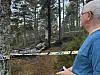 Mann i blå skjorte ved sperrebånd i en skog