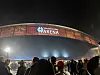 Folkemengde utenfor den opplyste Telenor Arena om kvelden.