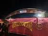 Rosa turnébuss med gul tekst og Arena-logo står opplyst i mørket.