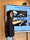 Kvinne står foran en skjerm med teksten «Velkommen til kick off Ålesund 2026».