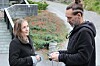 Kvinne og mann i samtale ved en trapp og et beplantet område.
