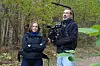 To personer i skogen, hvor den ene filmer med et videokamera.