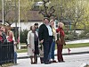 Gruppe mennesker samlet ved en gate med norsk flagg og vårgrønne trær.