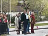 Gruppe mennesker samlet ved en gate med norsk flagg og vårgrønne trær.